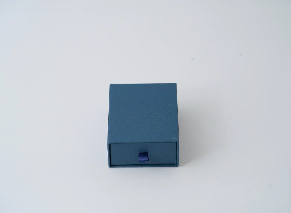 Caja cuadrada para joyería de 9×9×3,5 cm, diseñada para la presentación y resguardo de aretes grandes, dijes, anillos y sets pequeños de joyería. Fabricada en material rígido, ofrece una estructura resistente que protege las piezas durante la exhibición, entrega y almacenamiento. Su formato proporciona una presentación limpia y ordenada, adecuada para uso comercial.