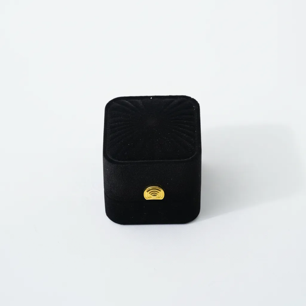 Caja de joyería compacta de 5,4×4,8×4 cm, diseñada para la presentación y resguardo de anillos y aretes. Cuenta con soporte interior que mantiene las piezas en posición estable. Su estructura rígida ofrece protección durante exhibición, almacenamiento y venta, brindando una presentación ordenada y profesional.