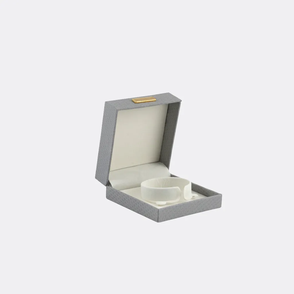 Empaque de joyería en tono gris de 9 × 9 × 4 cm, con presentación elegante y moderna. Su diseño sobrio lo hace ideal para marcas que buscan una estética limpia y sofisticada.