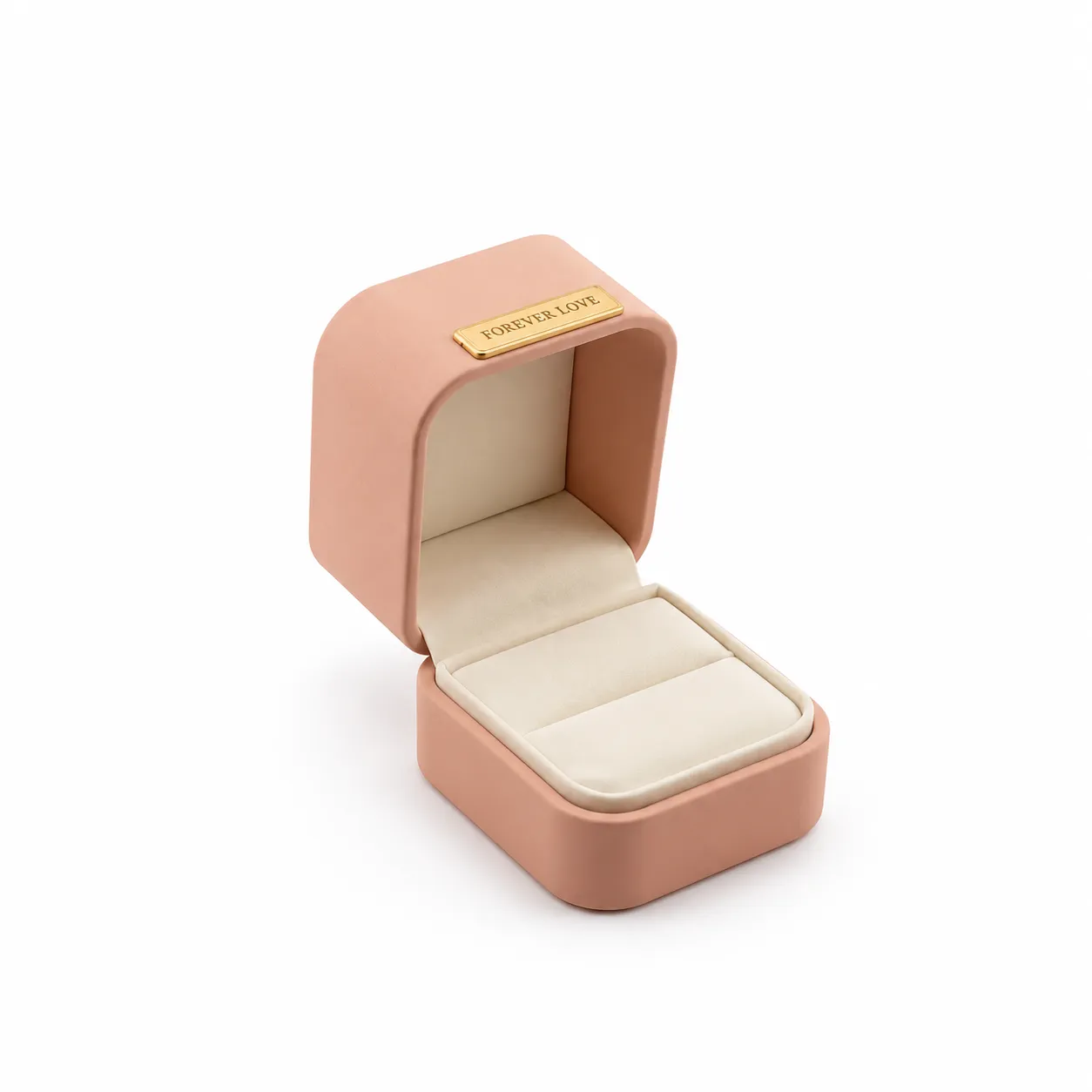 Empaque rígido de 5 × 6 × 5 cm en color palo rosa, con tapa abatible, interior acolchado en tono claro y aplique metálico dorado. Su formato compacto es ideal para presentar anillos, aretes y piezas pequeñas.