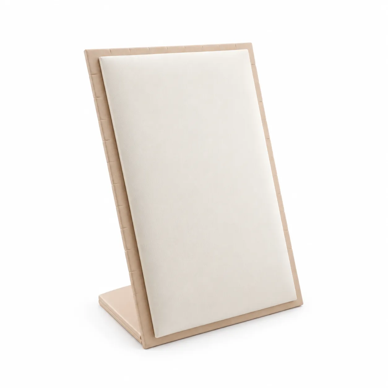 Exhibidor rectangular inclinado de 18 × 26 cm, con superficie acolchada en tono claro, marco de contraste suave y soporte posterior. Su ángulo facilita la visualización de cadenas, collares, dijes y conjuntos, logrando una presentación limpia y ordenada.